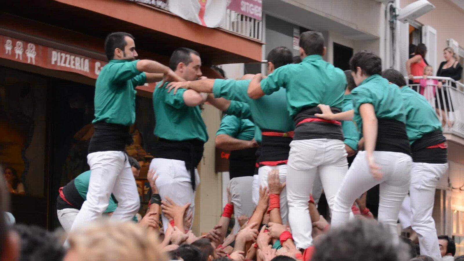 A human tower rising above spectators in a Catalan square